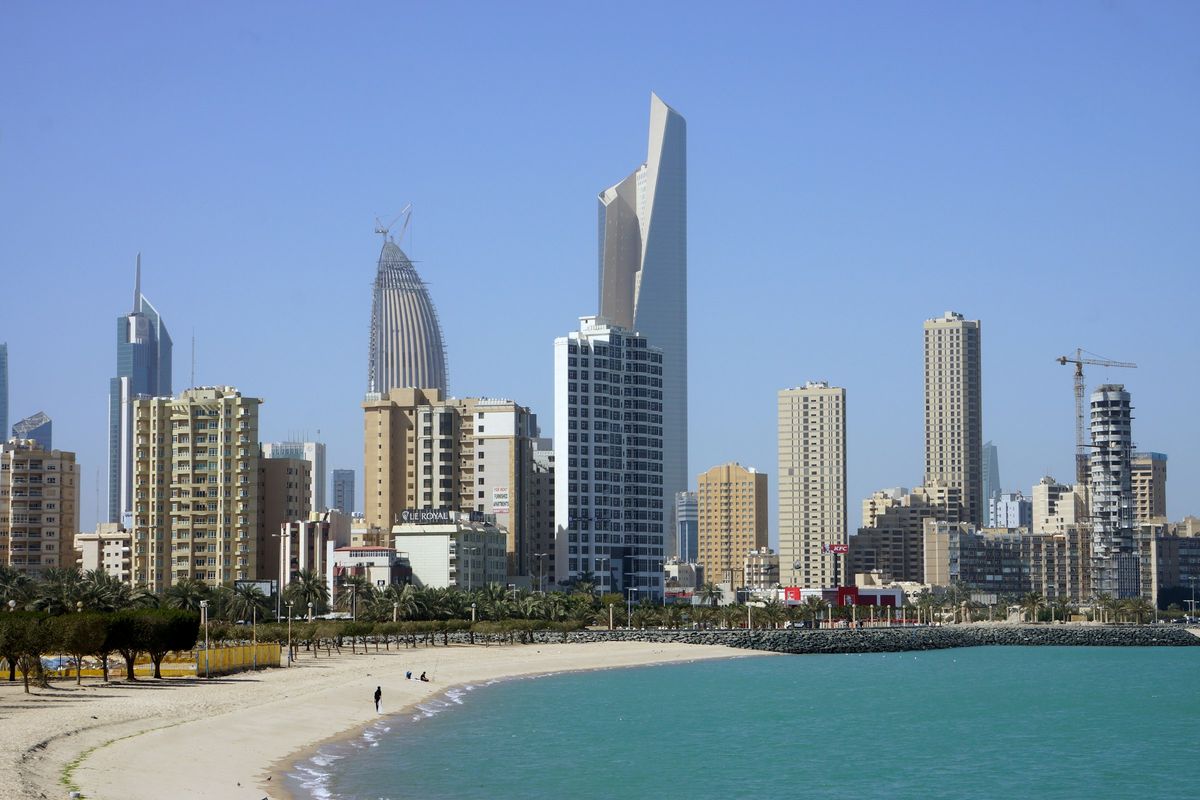 Kuwait City's towers seen from a sunny beach