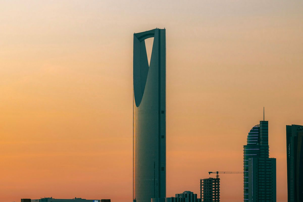 A landmark tower against a warm orange sky in Riyadh